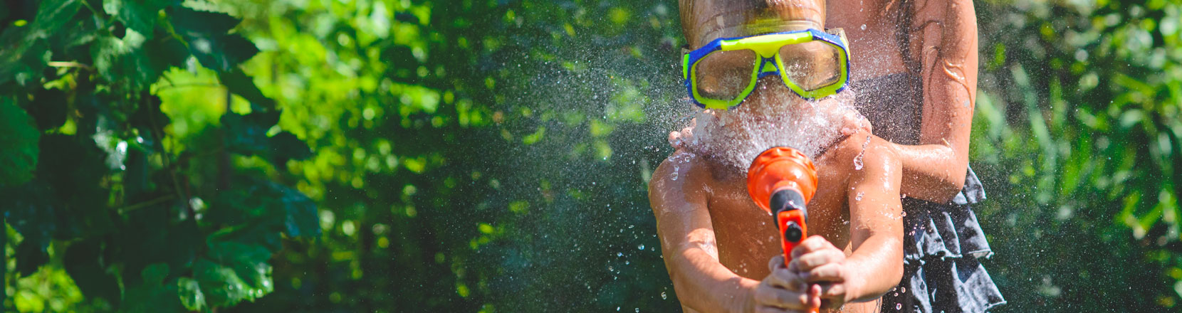 bambino si punta sul viso un getto d'acqua