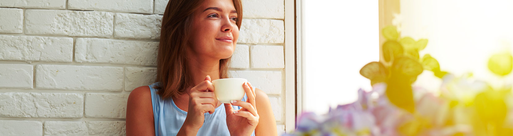 Donna che sorride al mattino mentre fa colazione