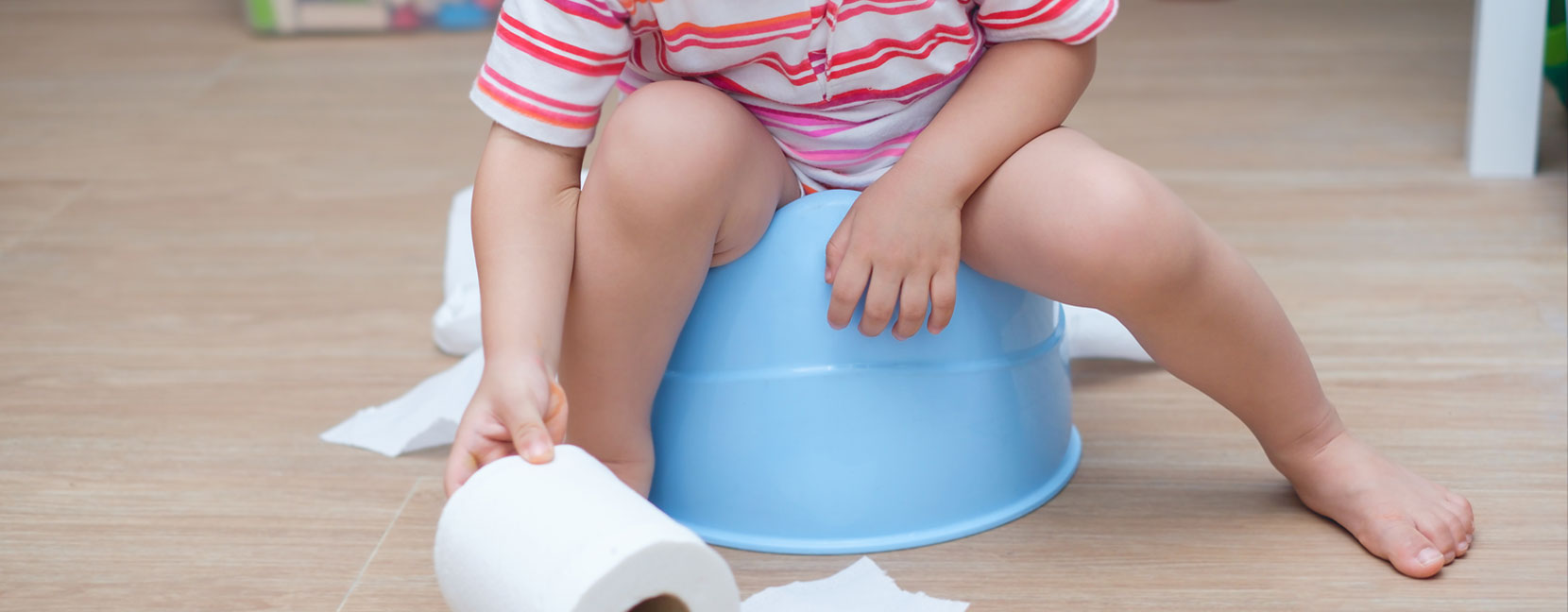 Bambino sul vasino gioca con la carta igienica