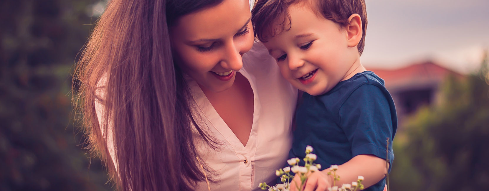 Mamma con il suo bambino raccolgono dei fiori