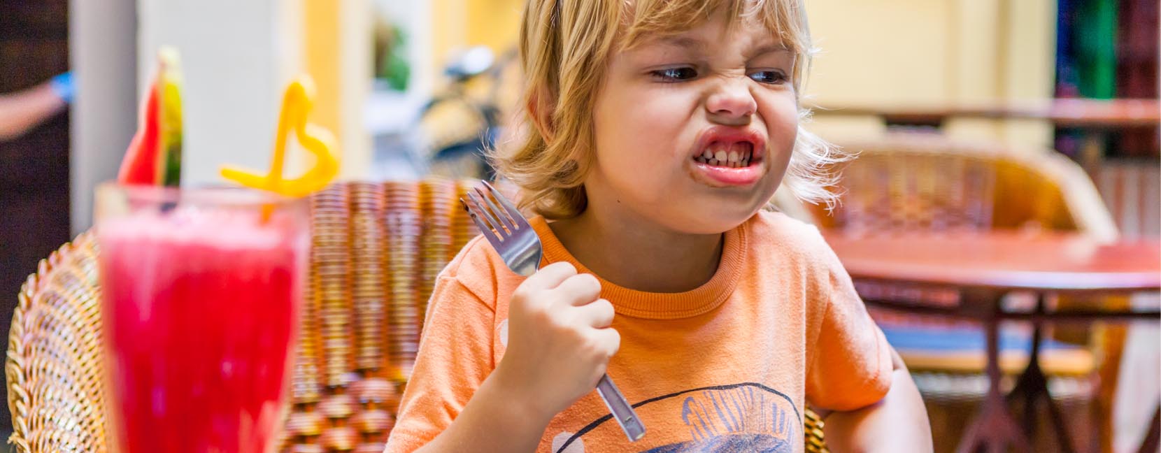 Bambino arrabbiato stringe in mano una forchetta minaccioso