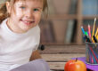 Si distrae durante i compiti, bambina che sorride mentre fa i compiti