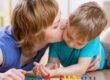 Mamma da un bacio al suo bimbo che ha un espressione rattristata