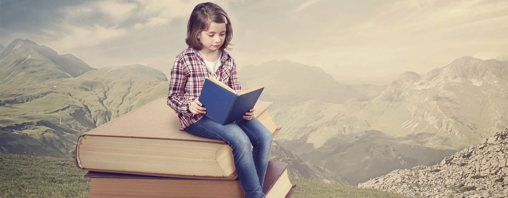 Bambina legge un libro seduta su una pila di libri giganti