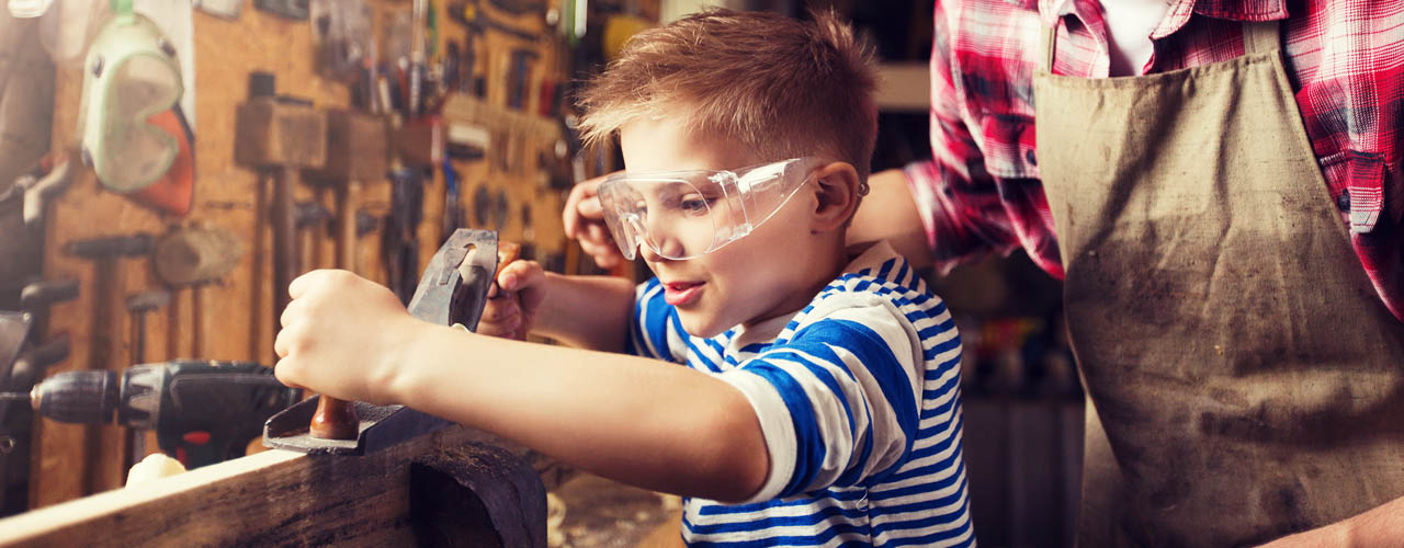 Pericoli in casa e bambini, bambino che usa strumenti pericolosi con il papà