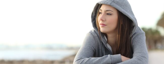 Si isola Ragazza pensierosa seduta da sola: si isola, non socializza, vuole stare da sola