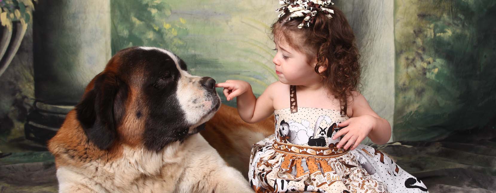 Bambina che tocca il naso di un grosso cane tranquillo