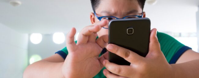 Spegnere TV videogiochi telefono tablet_1280x500 Bambino tutto concentrato ad usare un telefono