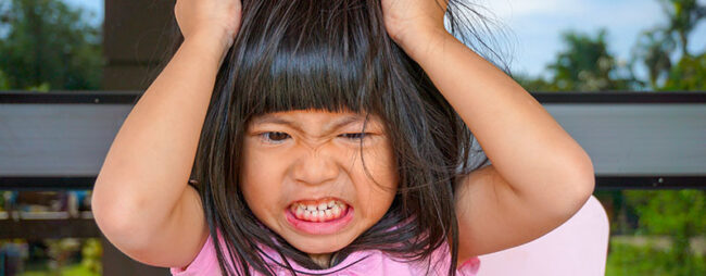 Bambina con crisi di rabbia digrigna i denti e si strappa i capelli