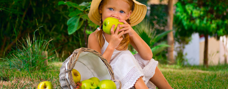 Bambina che addenta una mela