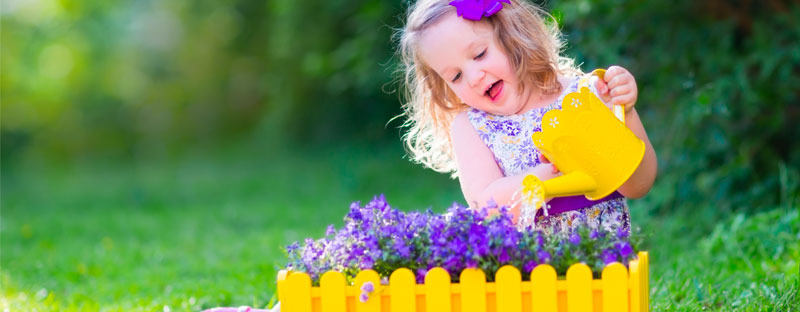 Bambina che annaffia i fiori