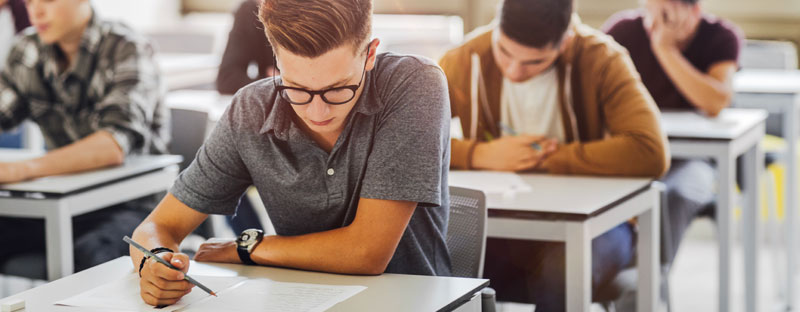 ragazzo sta facendo una verifica a scuola