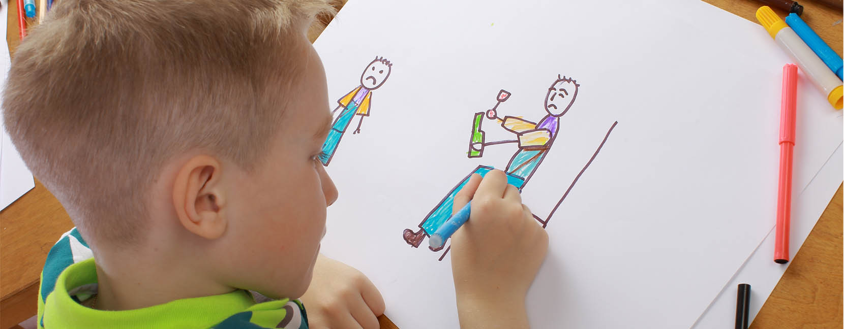 Bambino che disegna delle figure umane