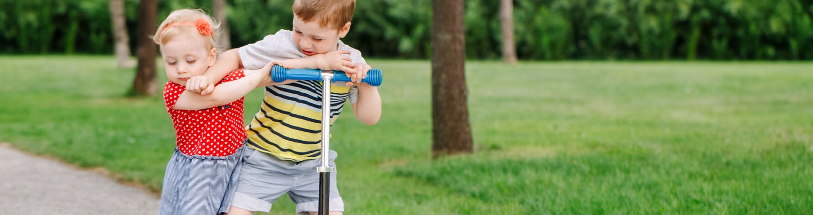 Non condivide i giochi, è egoista, bambino che spinge via una bambina per non farle provare il suo monopattino