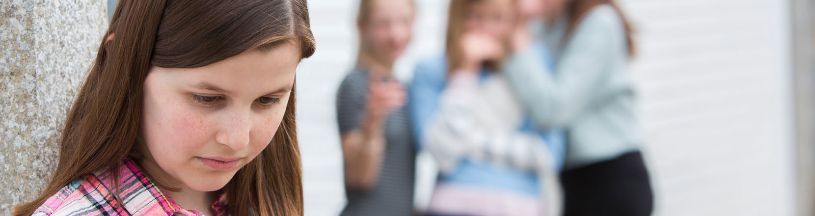 Ragazza si isola e altre la additano sullo sfondo, si sente diversa