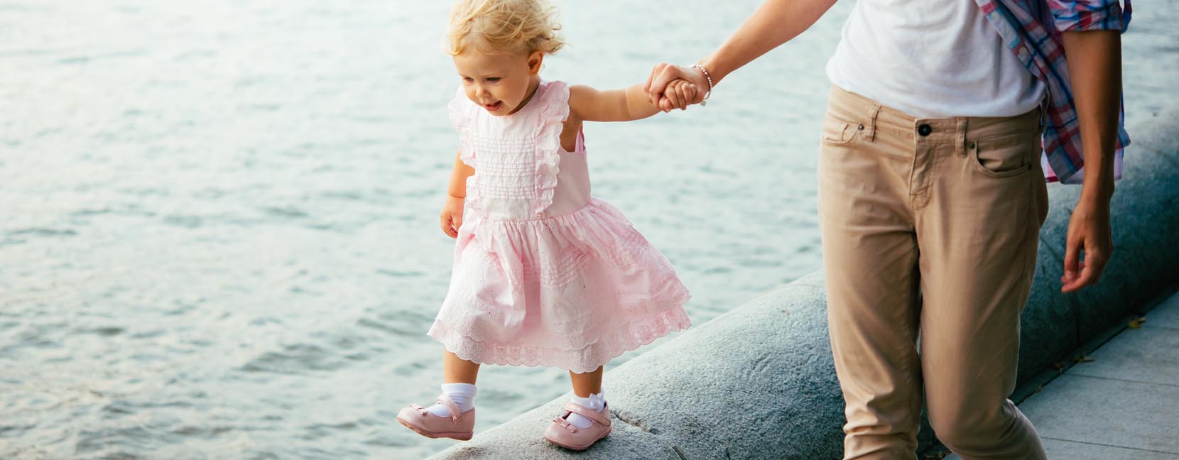  terrible two: mamma tiene la mano alla bimba mentre passeggia sul muretto