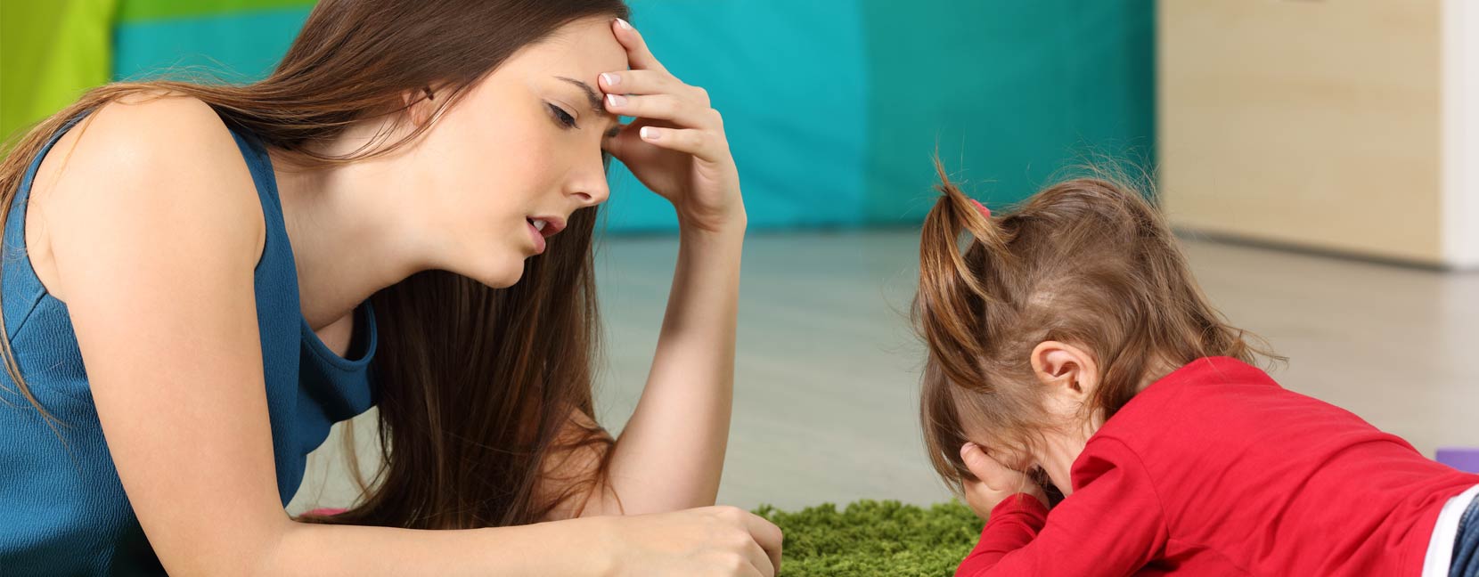 Mamma annoiata e un po' stufa guarda la sua bimba triste